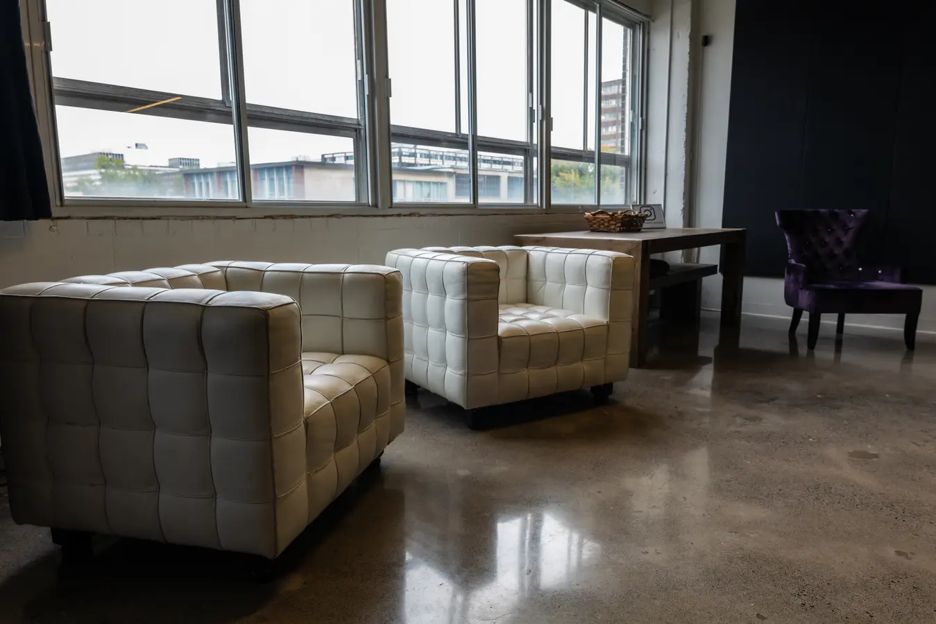 White tufted armchairs by the windows