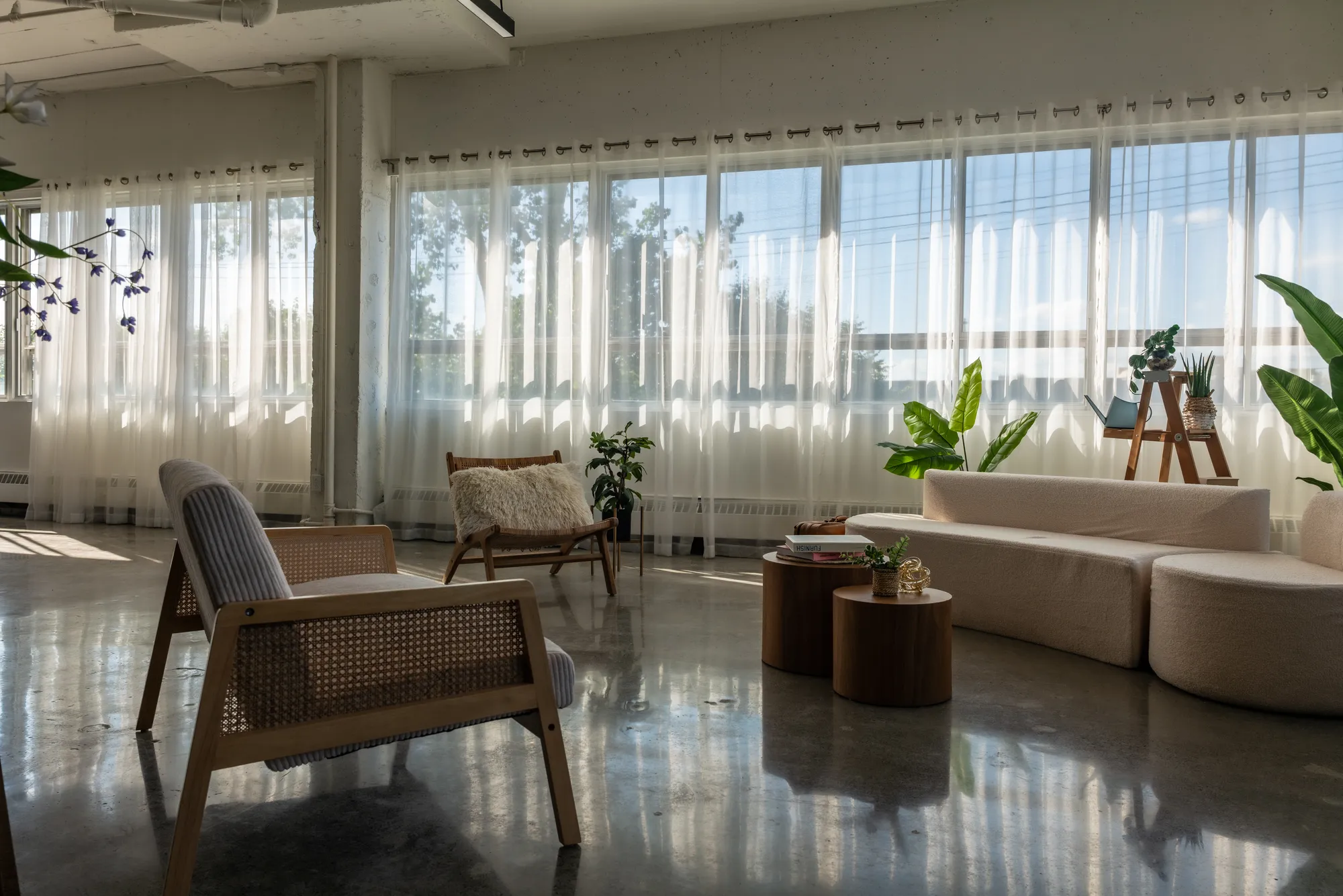 Bohemian lounge with a cream sofa and rattan armchairs