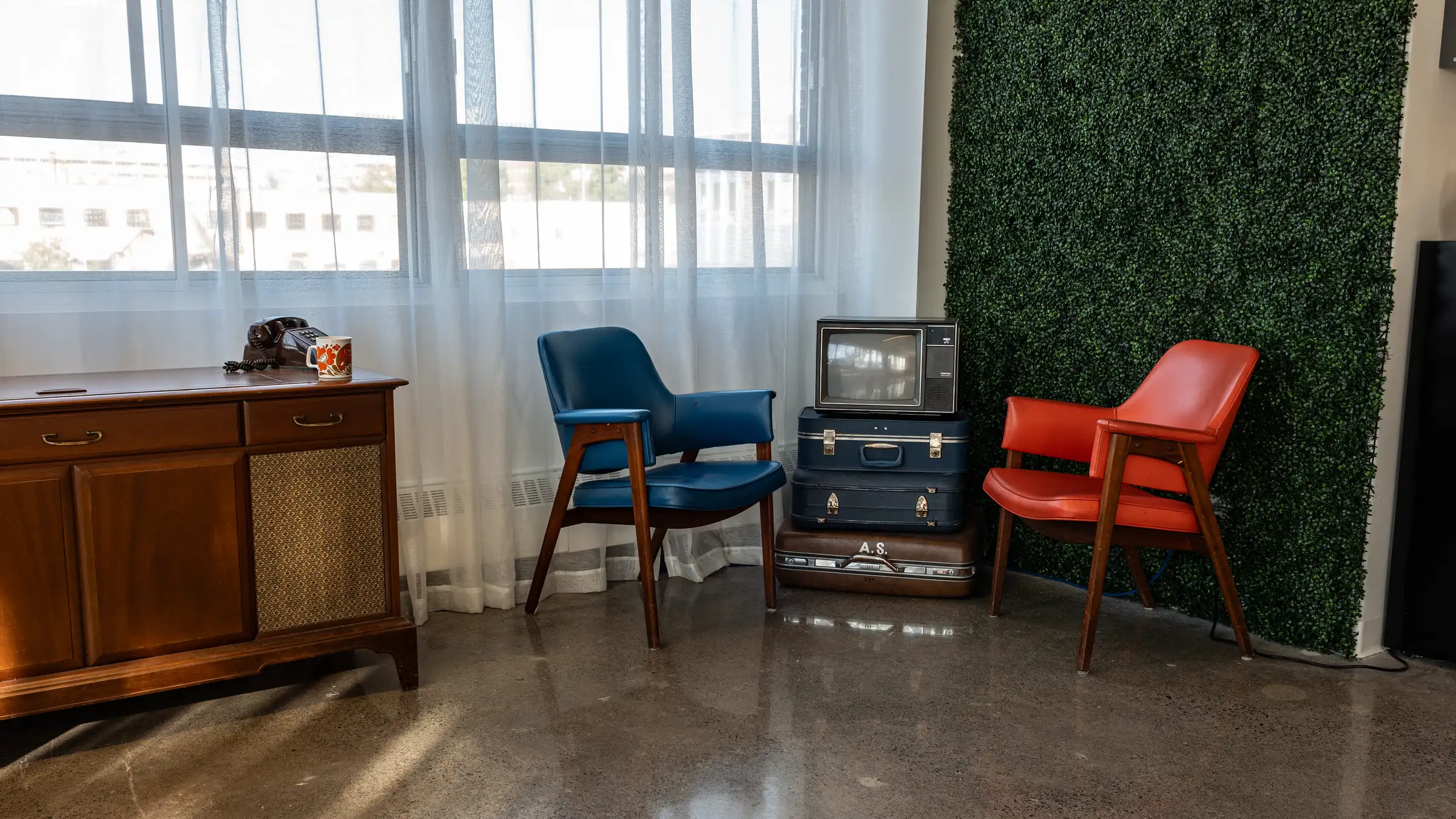 Coin rétro avec meuble radio vintage et fauteuils colorés, Espace Urbain Studio