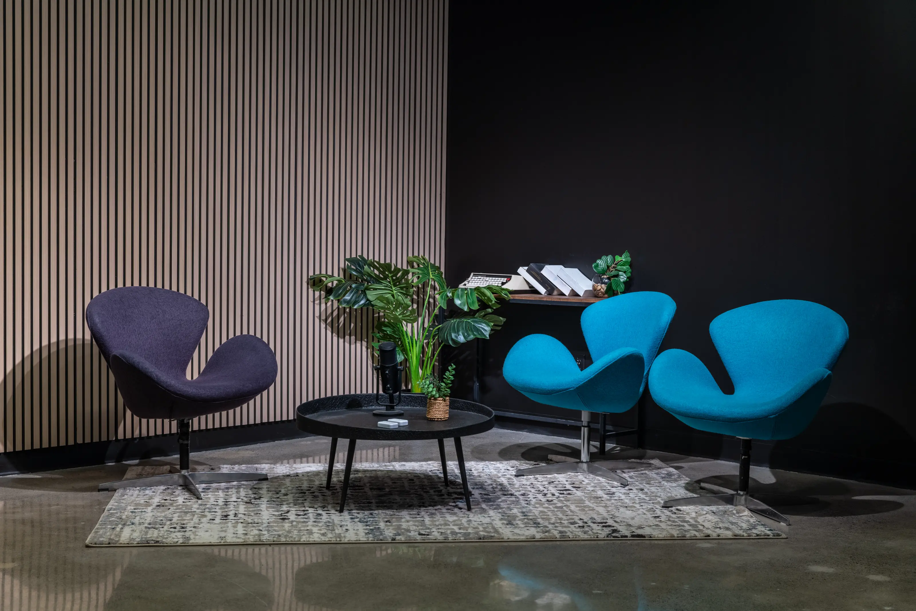 Plateau podcast du Studio B avec fauteuils, micros et mur de lattes acoustiques